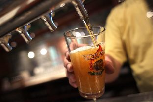 The bartender pours beer into a glass